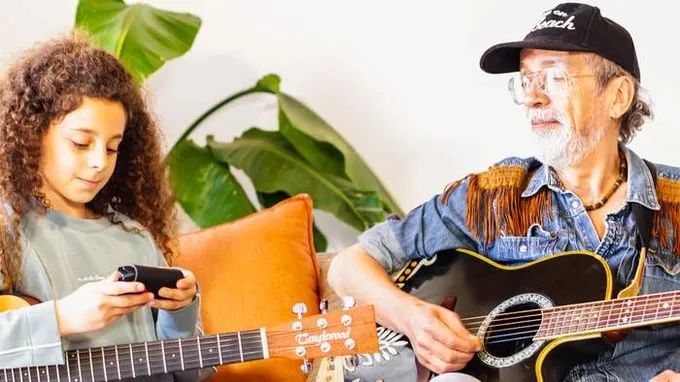 Teacher and student playing guitar